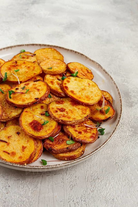 Crispy potato slices, with parmesan cheese and spices, fried in the oven, homemade, no people