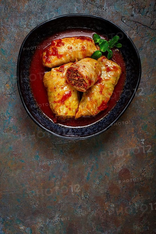 Stuffed cabbage rolls with minced meat, in tomato sauce, top view, without people, in the spotlight