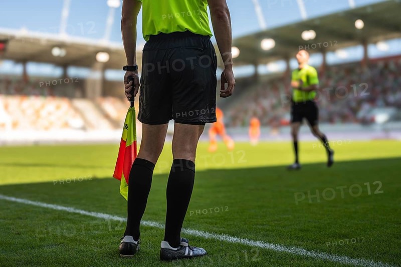 Legs of football sideline referee and main referee in the background in Lubin, Poland