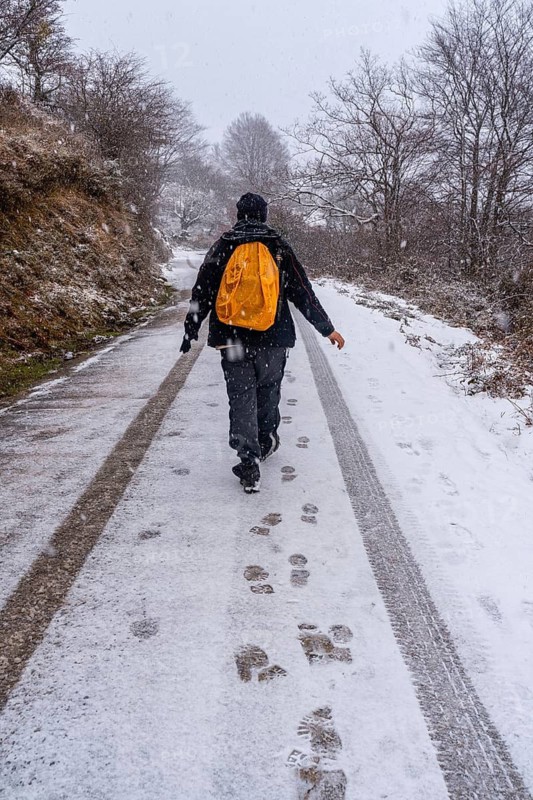 A young man enjoying himself on the snowy road of gipuzkoa's mount aizkorri. Snowy landscape by winter snows. Basque Country, Spain