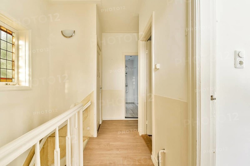 A spacious hallway featuring white walls, natural light, and wooden flooring, designed for a clean and modern aesthetic. Ideal for contemporary interior design inspiration