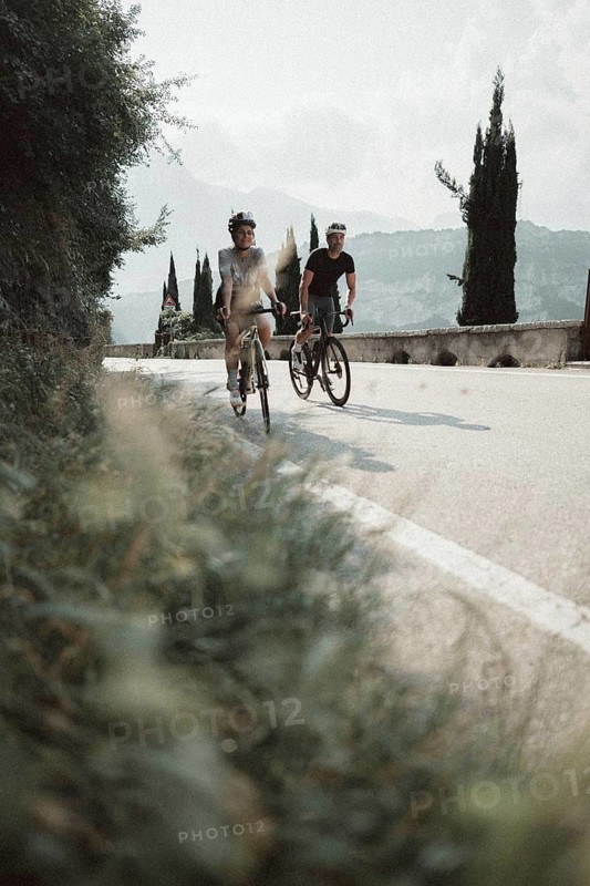 Woman and man riding racing bikes in Italy on Lake Garda