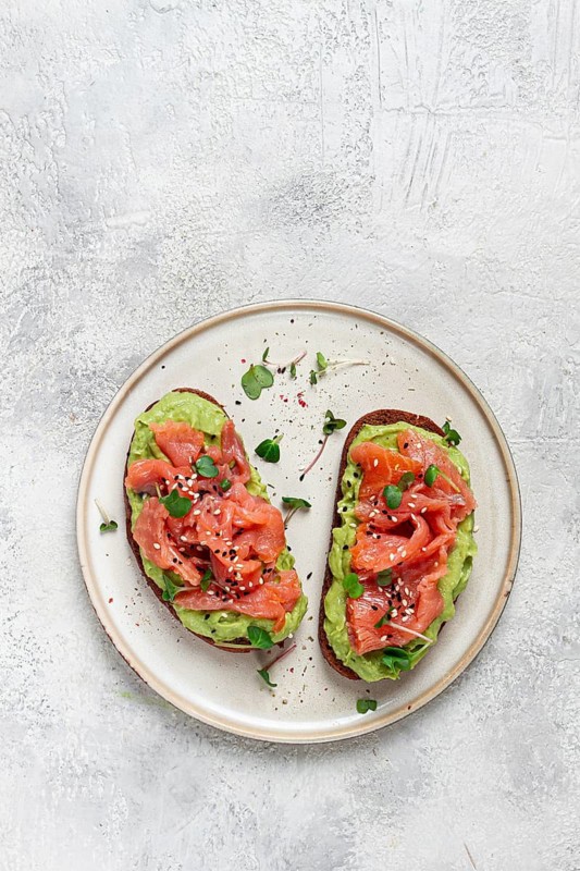 Breakfast, Sandwiches with smoked salmon and avocado, on dark rye bread, with microgreens, on a marble table, homemade, no people
