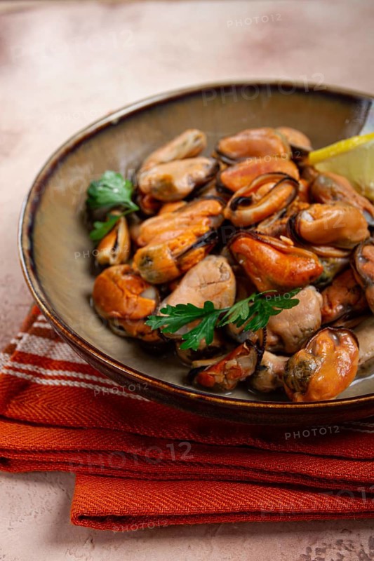 Mussels no shell, boiled, mussels, peeled, in a bowl, with lemon and parsley, Chilean mussels, top view, no people