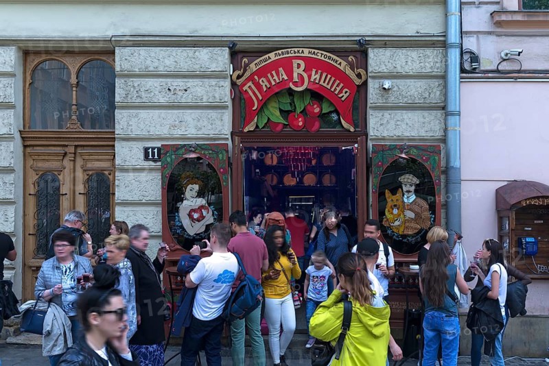 Young people having drinks in front of a tavern, Lviv, Ukraine