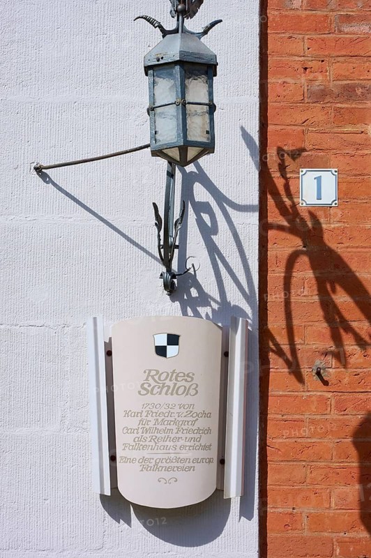 Sign and lantern on a brick wall cast shadows under bright light, Red Castle, Triesdorf, Weidenbach, Franconian Lake District, Ansbach District, Middle Franconia, Bavaria, Germany