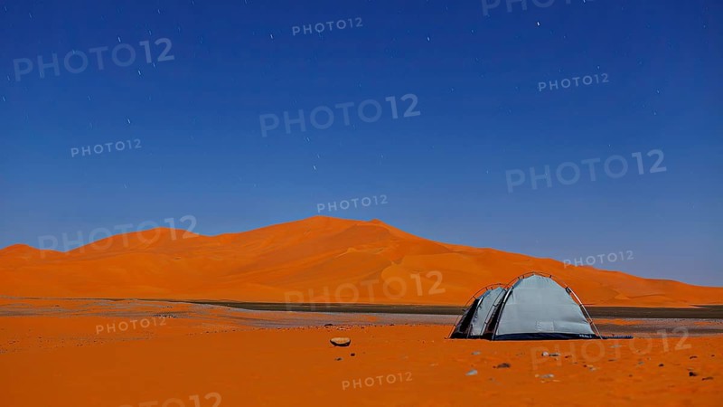 Single tent in a silent desert under a starry sky, tent camp in the dunes of the Sahara in Algeria