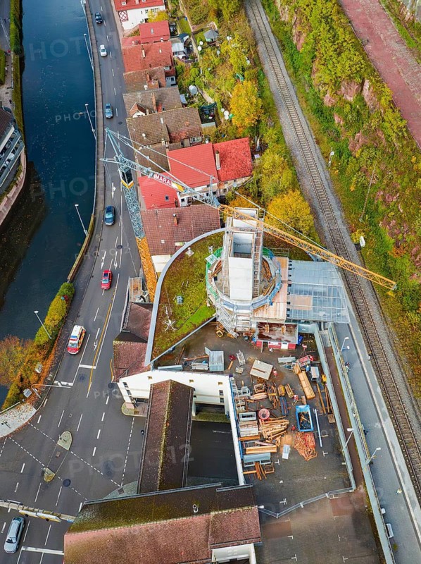 Aerial view of a construction site with construction crane and surrounding roads and river, extension of the Calw railway station for the new track of the Hermann Hessebahn, Calw, Black Forest, Germany