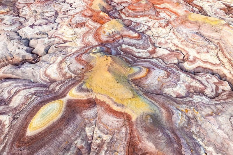 A stunning aerial view of colorful bentonite sandstone formations in Utah, USA. The vibrant patterns and textures showcase natural beauty and geological wonder
