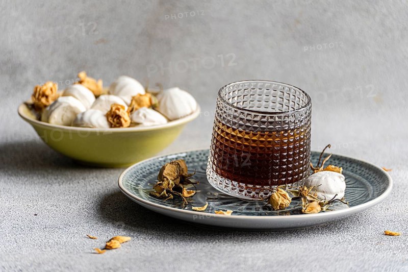 A delightful pairing of homemade vanilla mini zephyr-marshmallow filled with rose jam and an iced coffee liqueur drink, perfect for a sophisticated dessert experience