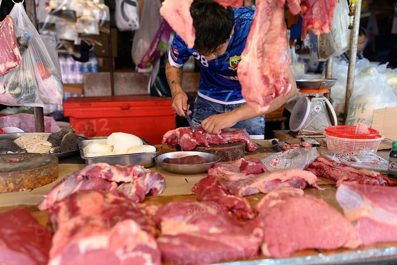Bangkok, Thailand. February 19th 2025. A local Thai butcher trimming meat at a stall in the Khlong Toei Market, Bangkok