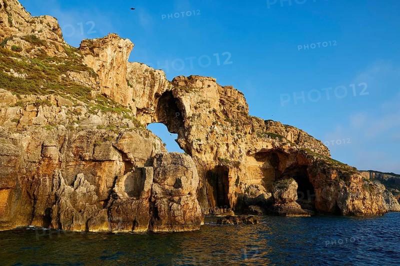 A large rock formation with a natural arc over the sea, morning light, Tsichli Babas islet, Navarino Bay, Pylos, Peloponnese, Greece