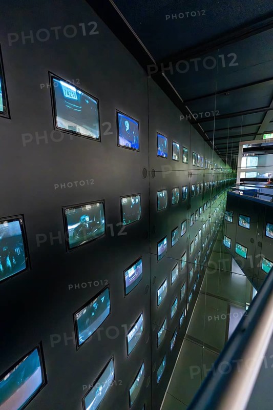Dark, modern showroom with numerous illuminated screens on the walls, Deutsche Kinematik, Berlin, Germany