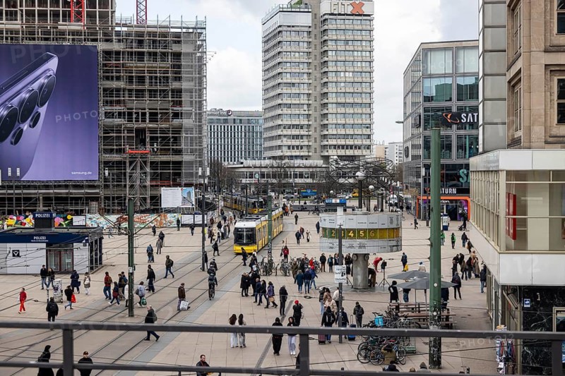 View of Alexanderplatz in Berlin with people and world clock. Tram Covivio Tower construction site. Berlin, Germany