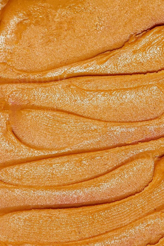 A close-up image showcasing the smooth, creamy texture of freshly spread peanut butter with distinctive, even lines across the surface