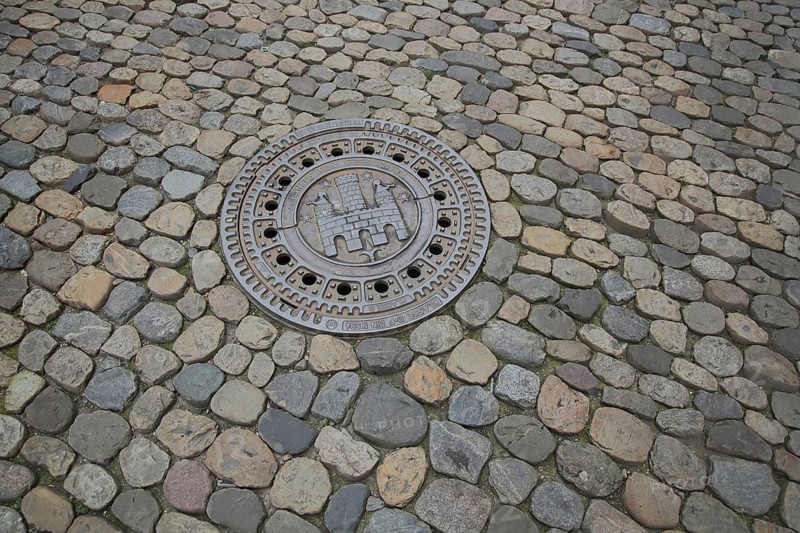 Manhole cover with city coat of arms, paving stones, soil, Freiburg, Breisgau, Southern Black Forest, Black Forest, Baden-Württemberg, Germany