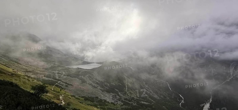 Mountains covered in fog with a distant lake in the background, Morskie oko, Zakopane, hiking in the High Tatras National Park, Carpathian Mountains, Poland