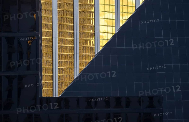 A visually striking composition of modern architecture in Las Vegas. The image features contrasting textures and colors, with reflective gold and sleek dark surfaces