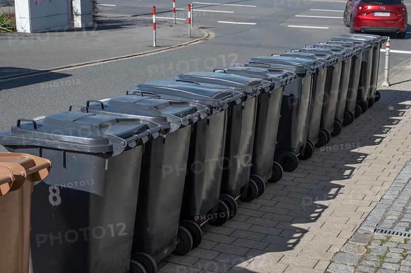 Garbage bins lined up on the street ready for collection, Eckental, Middle Franconia, Bavaria, Germany