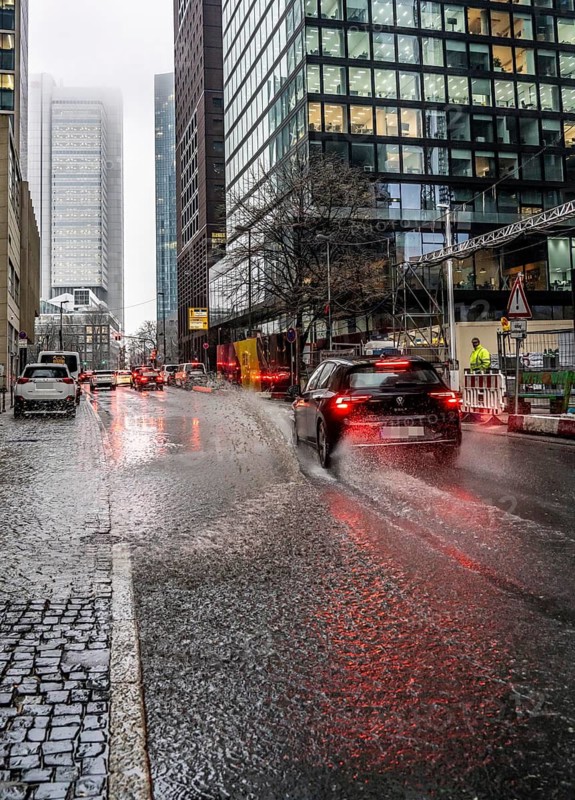 Winter, rainy weather, freezing rain, large puddle, puddle of water, in the city centre, Große Gallusstraße, vehicles driving through, spraying water fountains, Frankfurt am Main, Hesse, Germany