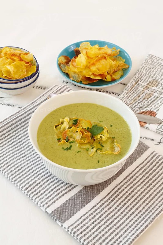 Swabian cuisine, cress soup with crisps, cress, plate with green cream soup, soup bowl, garnished with herbs, hearty soup, bowl with crisps, tea towel, writing, letters, vegetarian, healthy, salty, cooking, typical Swabian reinterpreted, traditional cuisine, food photography, studio, tablecloth, Germany