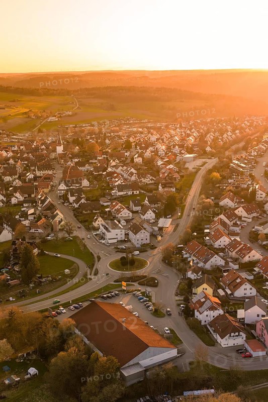 View of the center of a village with a roundabout in warm sunset light, Calw, Stammheim, Calw district, Germany