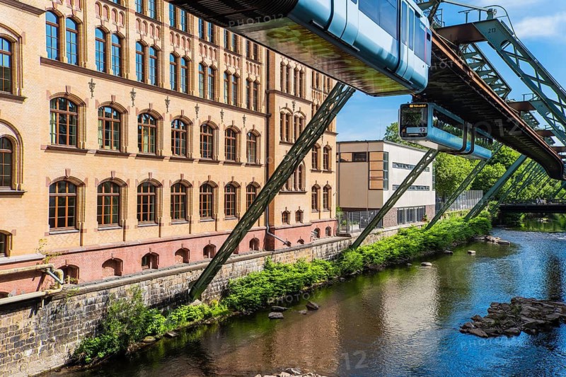 The Wuppertal suspension railway runs through a historic district near the Robert-Daum-Platz stop in Wuppertal, Germany