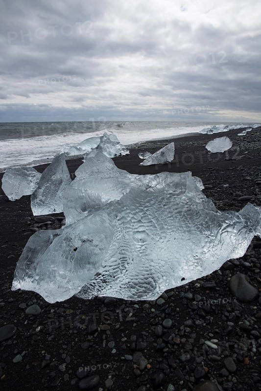 Little icebergs and crushed ice on the black beach at Joekulsarlon glacial lake