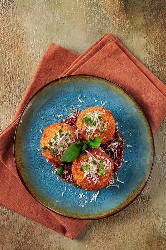 Crispy Arancini appetizer, with parmesan cheese and microgreens, plate, tomato sauce, homemade, no people
