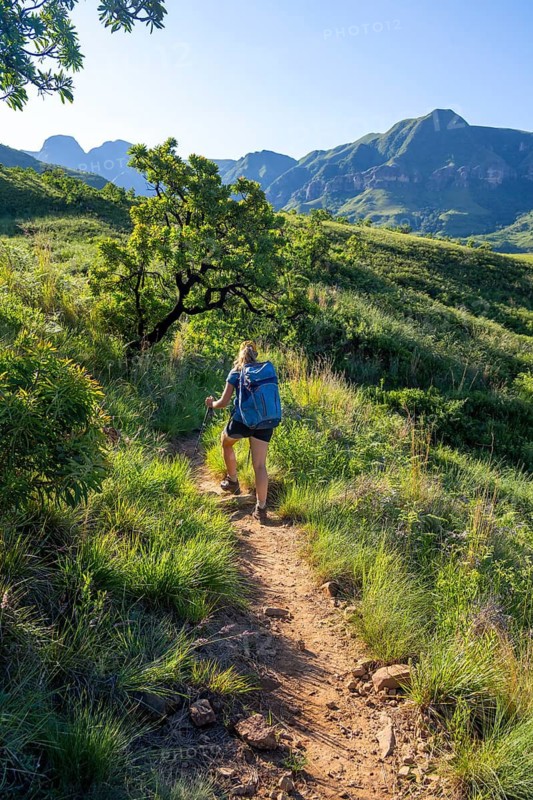 Young female hiker between mountains, Drakensberg National Park, KwaZulu Natal, South Africa