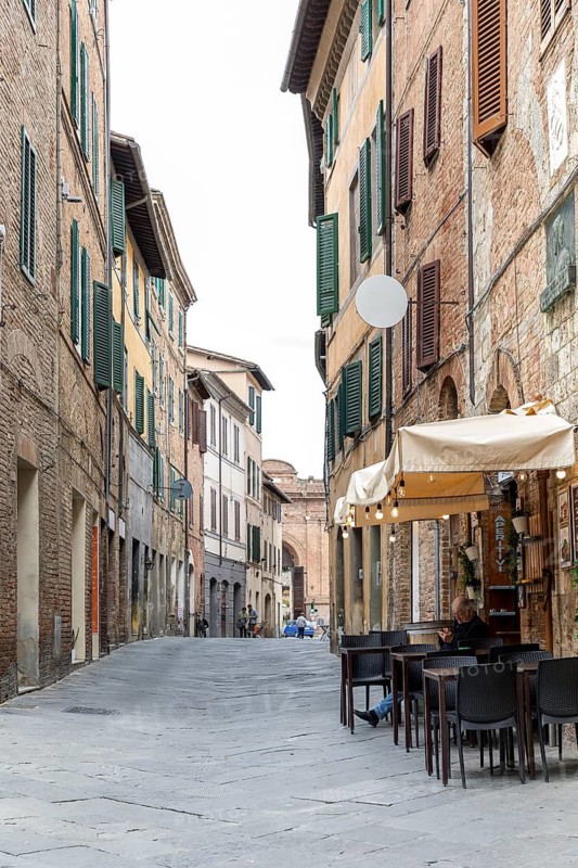 Small shopping street in the historic centre of Siena, Tuscany, Italy