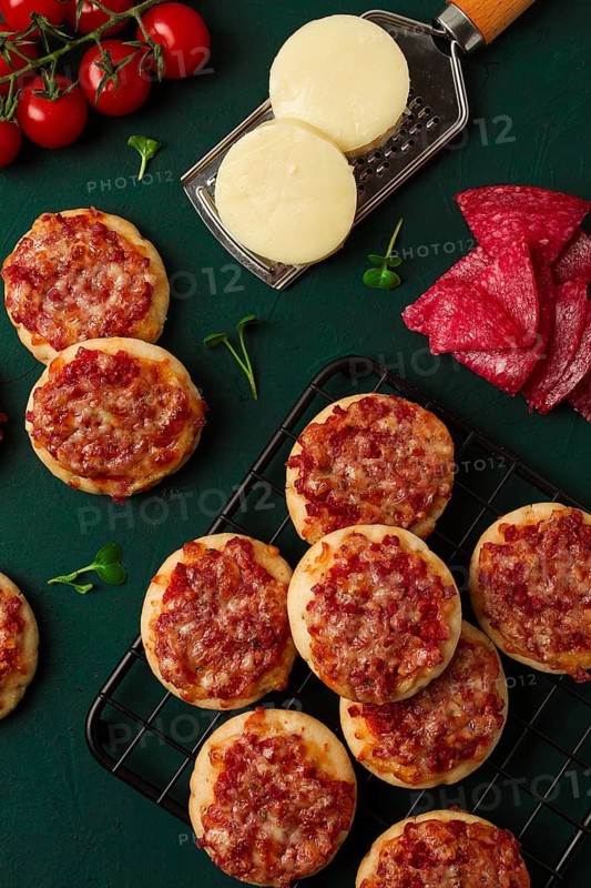 Mini pizzas, salami with mozzarella cheese, on the table, top view, no people