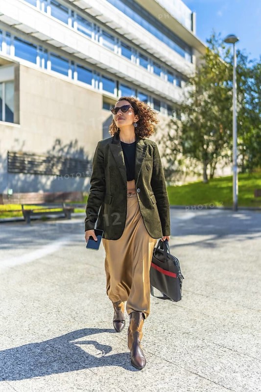 Vertical photo of a modern arab entrepreneur walking confident along city