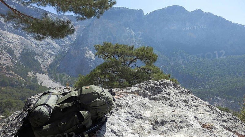 Rucksack on a rocky outcrop in front of a picturesque mountain panorama, hiking on the Lycian Trail, Lycia, Turkey