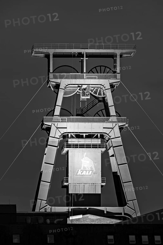 An impressive black and white mining tower with distinct technical structures and industrial character, The mining tower of the potash mine in Philippsthal in Hesse