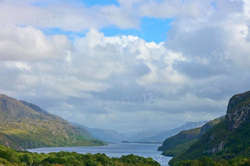 View of a long lake surrounded by green mountains and cloudy sky, Loch Maree, Taagan, Achnasheen, Scotland, United Kingdom, Great Britain