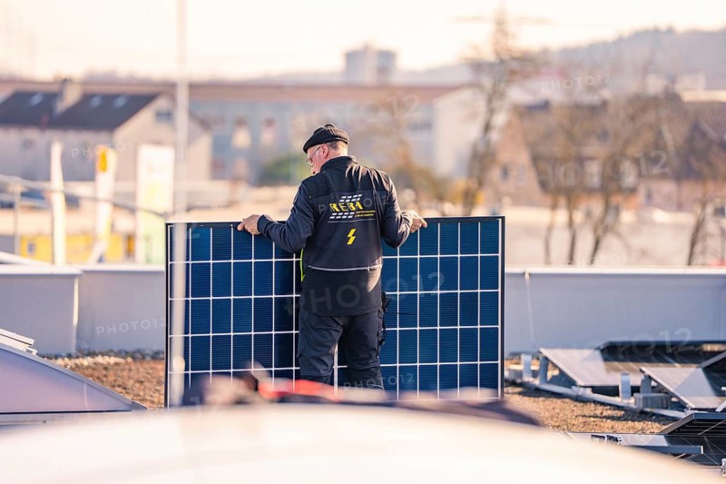Man sets up solar module, prepares installation on the roof, PV installation at OBI Baumarkt, Mühlacker, Enzkreis, Germany