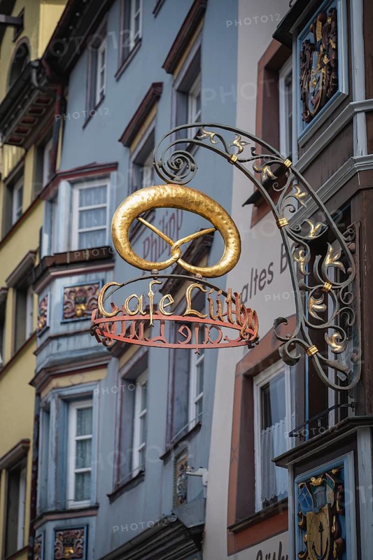 Traditional guild symbol for baking crafts, nose sign with the lettering Cafe Lüthy and a golden pretzel in the historic old town of Rottweil, Rottweil district, Baden-Württemberg, Germany