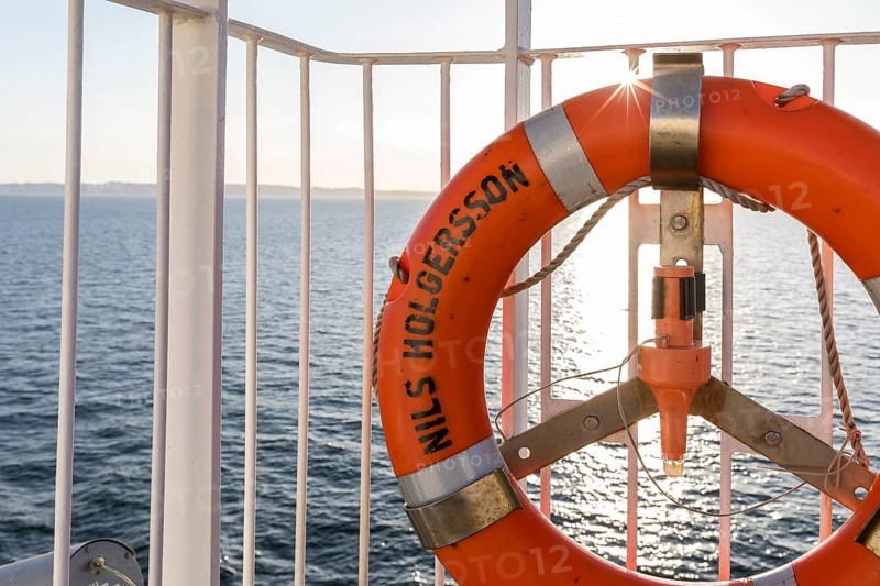 Lifebuoy on the railing of the TT-Line ferry Nils Holgersson with sun on the Baltic Sea