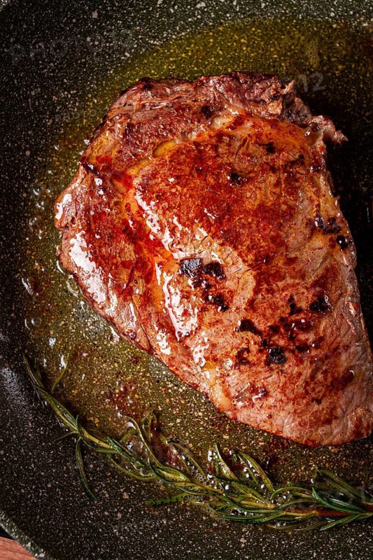 Fried steak, beef steak, rib eye steak, in a frying pan, top view, no people