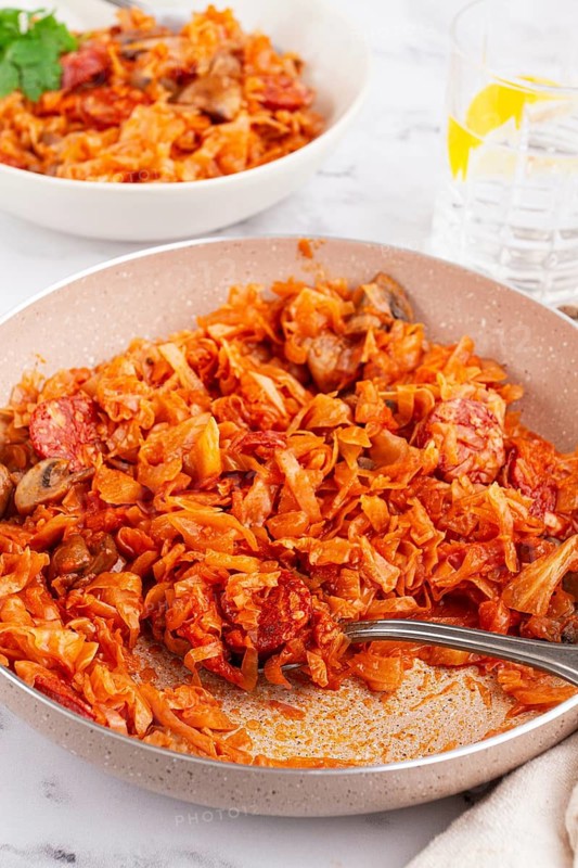 Bigos, Polish dish bigos, on the table, pan with stewed meat, with cabbage, chorizo sausages, mushrooms, homemade, without people