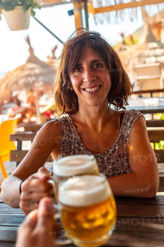 Toast of a couple on the beach in summer drinking a few beers on summer vacation