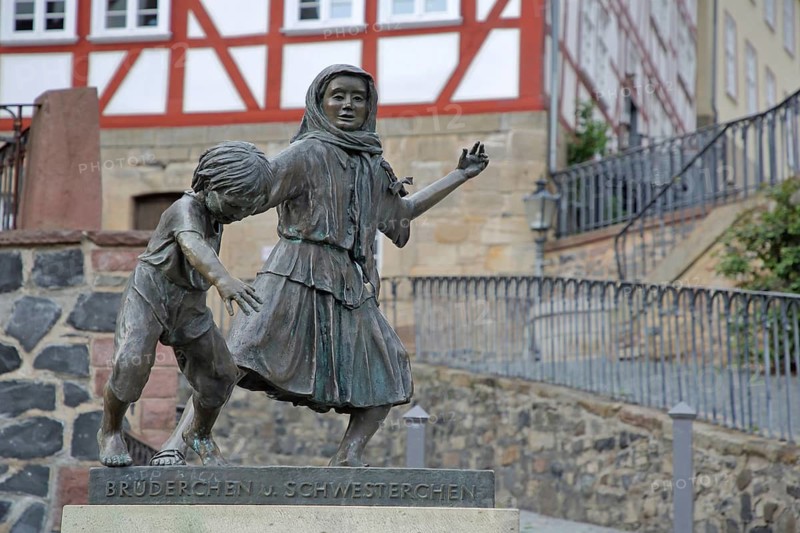 Brother and Sister sculpture by Ewald Rumpf 1997, two fairytale characters, modern art, bronze sculptures, life-size, boy and girl dancing, moving, inscription, Deutsche Märchenstraße, Marktplatz, Homberg-Efze, Hesse, Germany