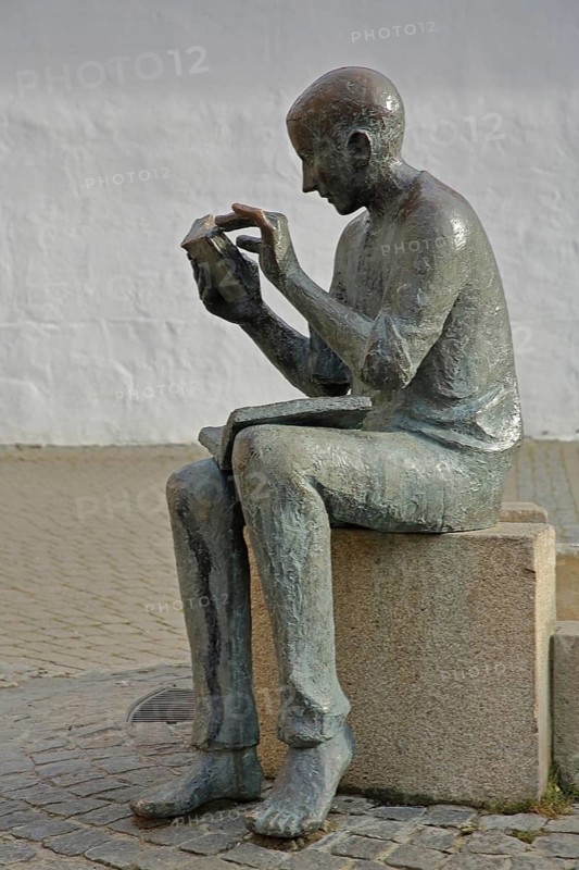 Sculpture Book reader at the fountain in front of the town library, reader, literature, books, book, reading, head, figure, holding, hand, bronze sculpture, Pfleghof, Langenau, Alb-Donau-Kreis, Swabian Alb, Baden-Württemberg, Germany