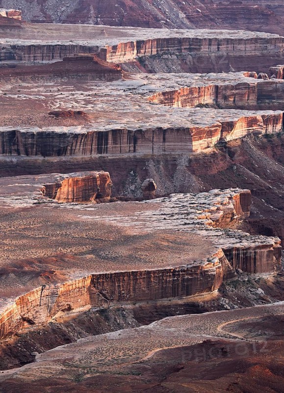 Aerial view of the breathtaking landscapes of Canyonlands National Park, showcasing dramatic cliffs and unique geological formations illuminated by sunlight