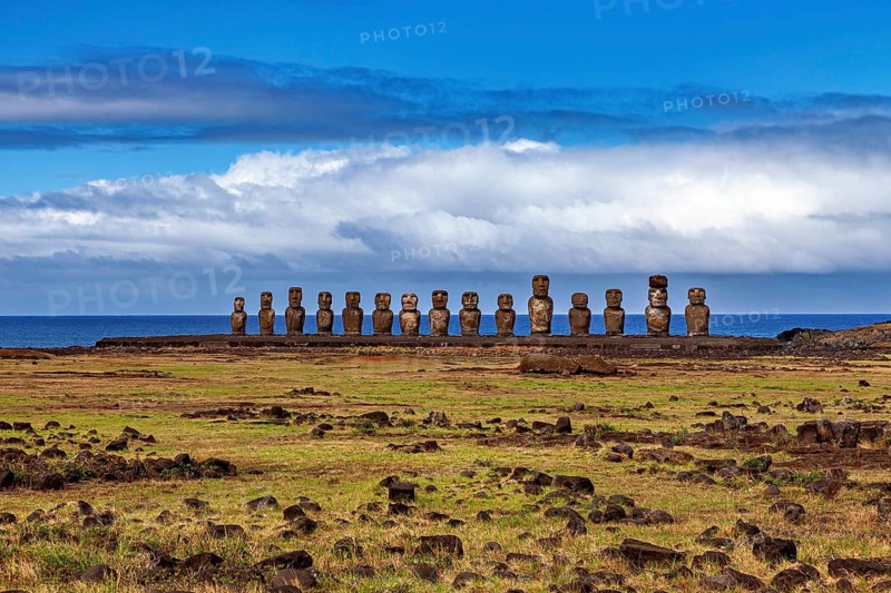 A group of Moai statues under a cloudy sky on a vast grassland, The Moai Statues on Easter Island in the Pacific Ocean