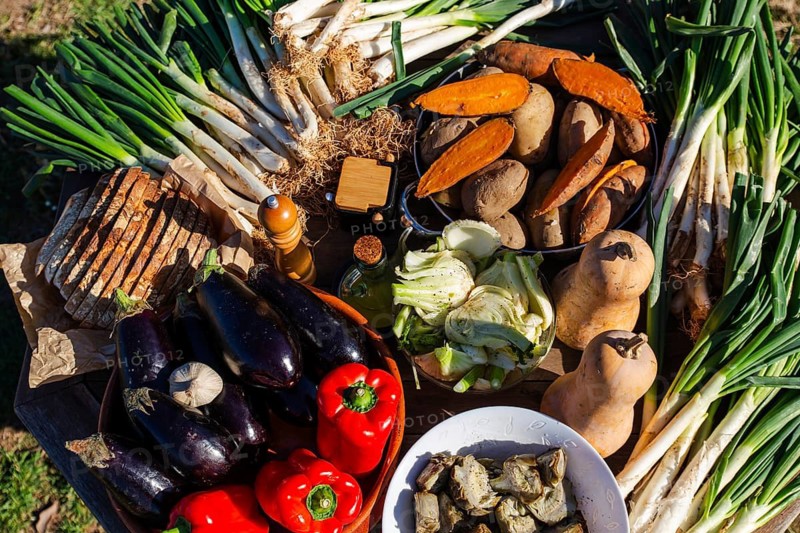 A vibrant display of ingredients for calsotada, showcasing fresh vegetables, bread, and spices. Experience the essence of Catalan culture and farm-to-table dining