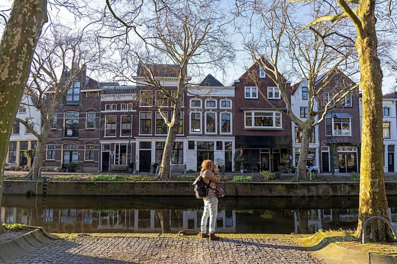 Houses on the river Binnengouwe, woman photographed, Gouda, Holland, Netherlands