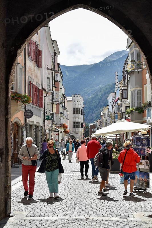 View through the gate in the Zwölferturm on the old town of Sterzing with many tourists, South Tyrol, Italy
