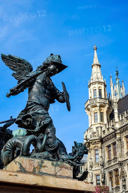 Depiction of allegorical battles against monsters, sculptures at the foot of St Mary's Column, with the town hall in the background, on Marienplatz in Munich, Bavaria, Germany